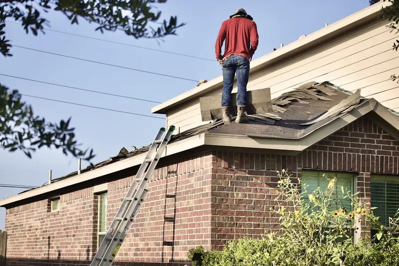 Professional roofer working on a residential roof in Delwood